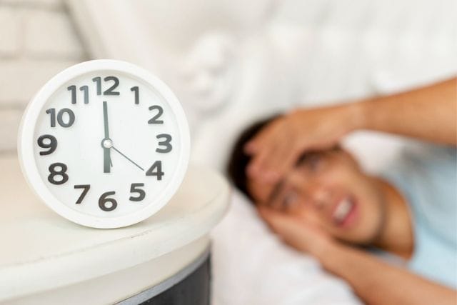 close-up-blurred-sleepy-guy-with-clock