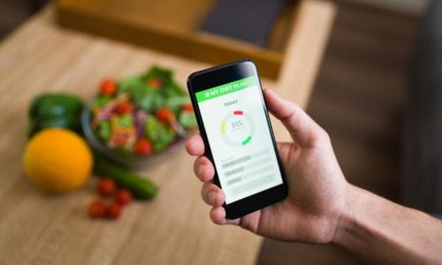 healthy-diet-male-hands-holding-smartphone-keeping-track-calories-his-food-with-fitness-app